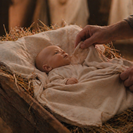 ALT TEXT Realistic baby Jesus doll placed in a nativity scene manger