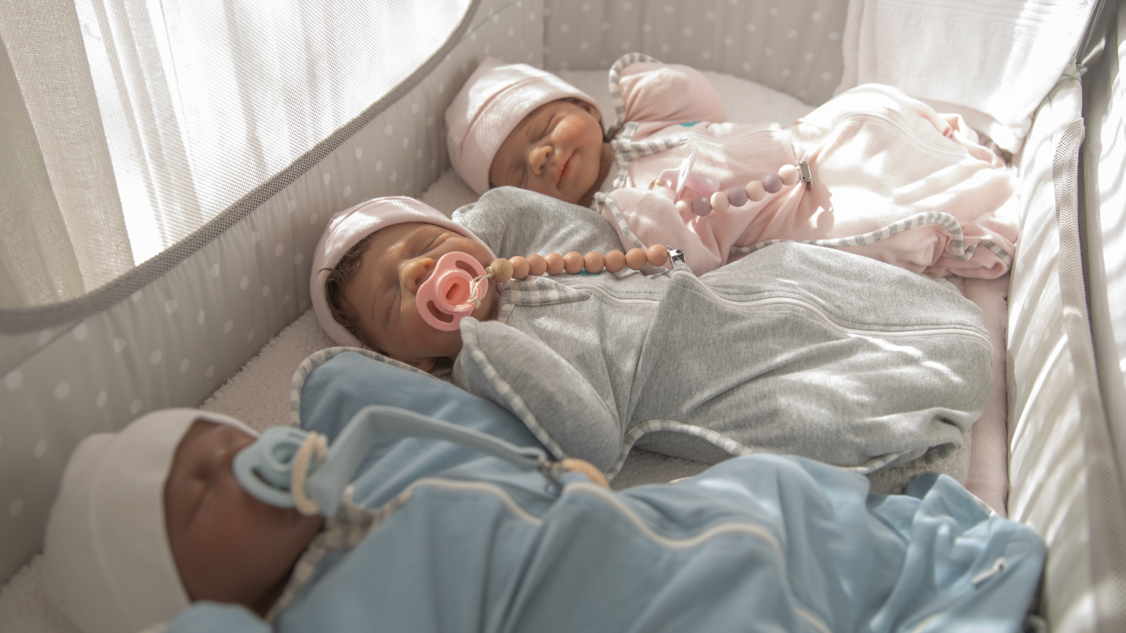Nurtura full body silicone babies Big Hugs girls and Calming Naptime boy resting together in bassinet