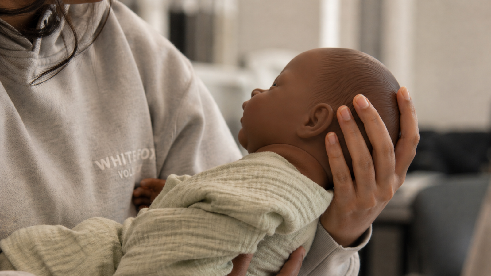 Student holding a realistic baby doll to learn safe positioning in early parenting education