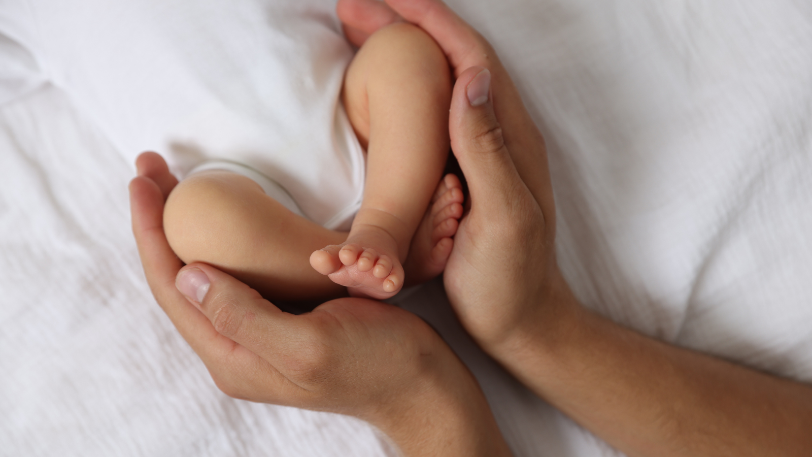 Realistic baby doll being gently held in hands, showing lifelike size, weight and comforting presence